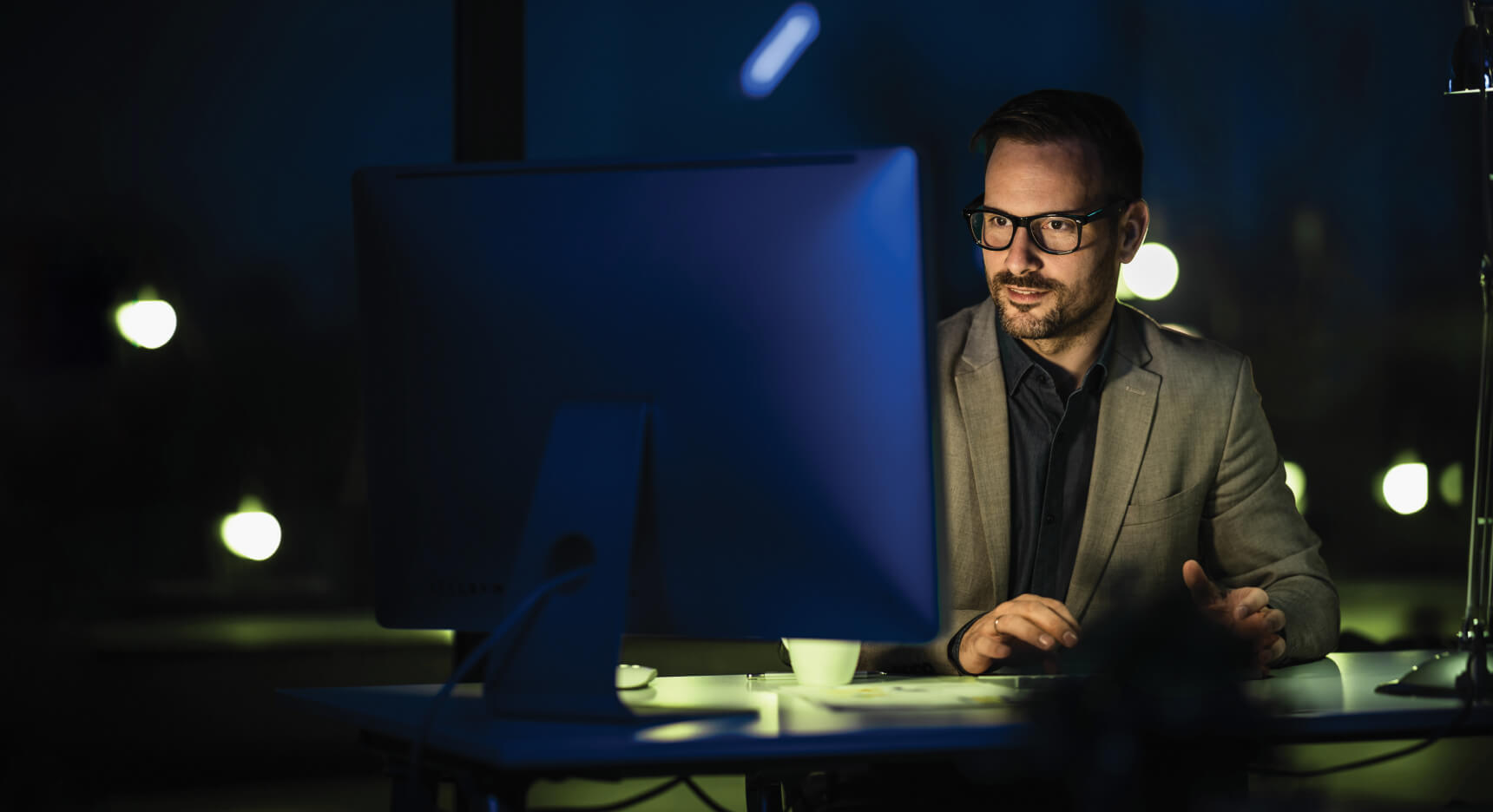 Become a Pepperstone Pro -  Man working on computer with dark background
